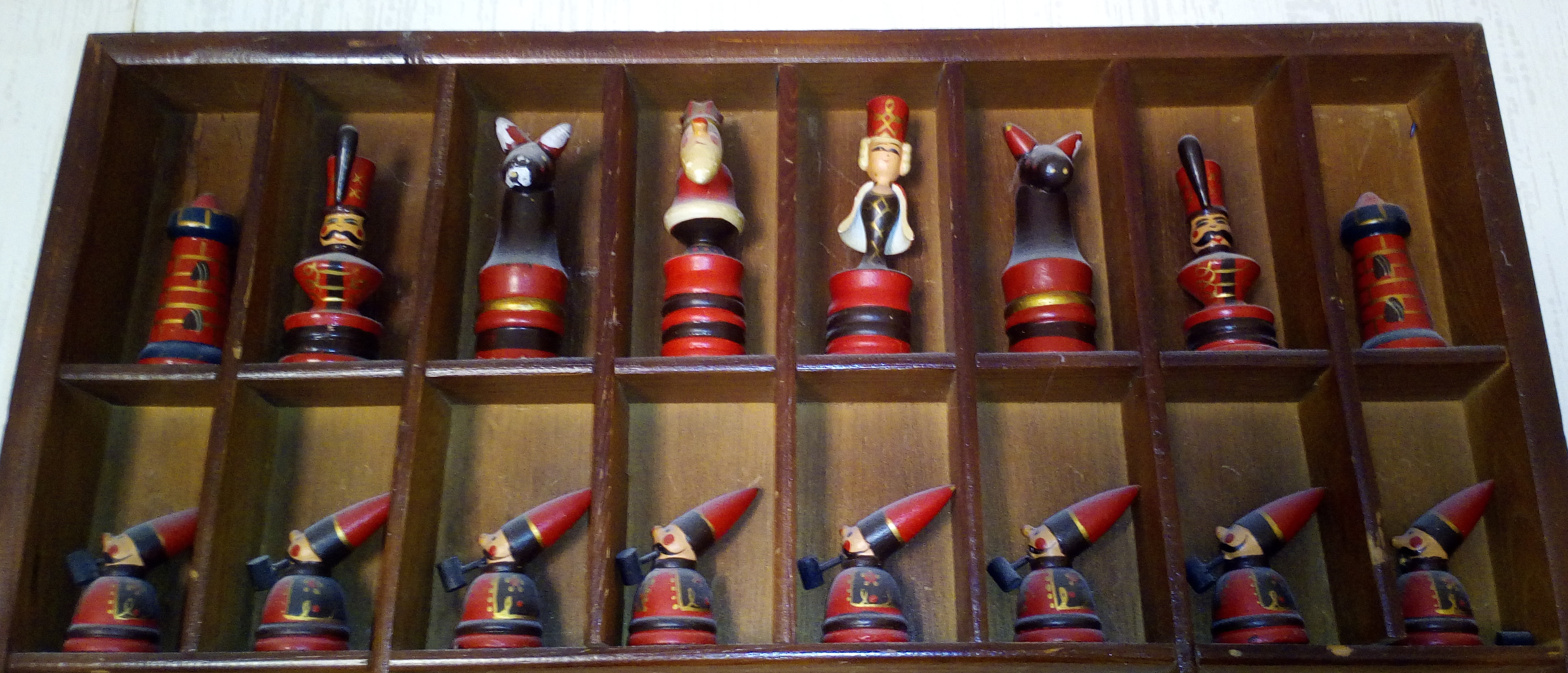 Ein Foto von diversen hölzernen Schachfiguren; die Bauern rauchen Pfeife.